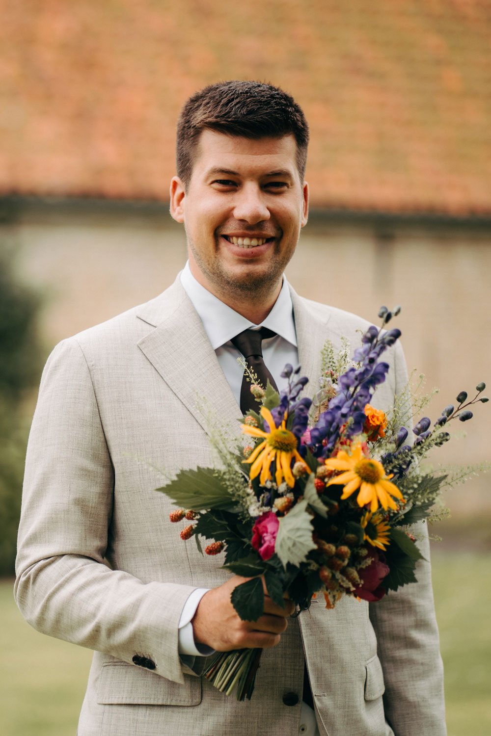Bruidegom met bloemen in trouwkostuum